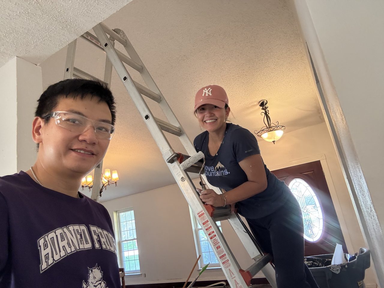 Hung Lam and his wife mid-remodel in one of their rentals, paint roller and ladder in hand